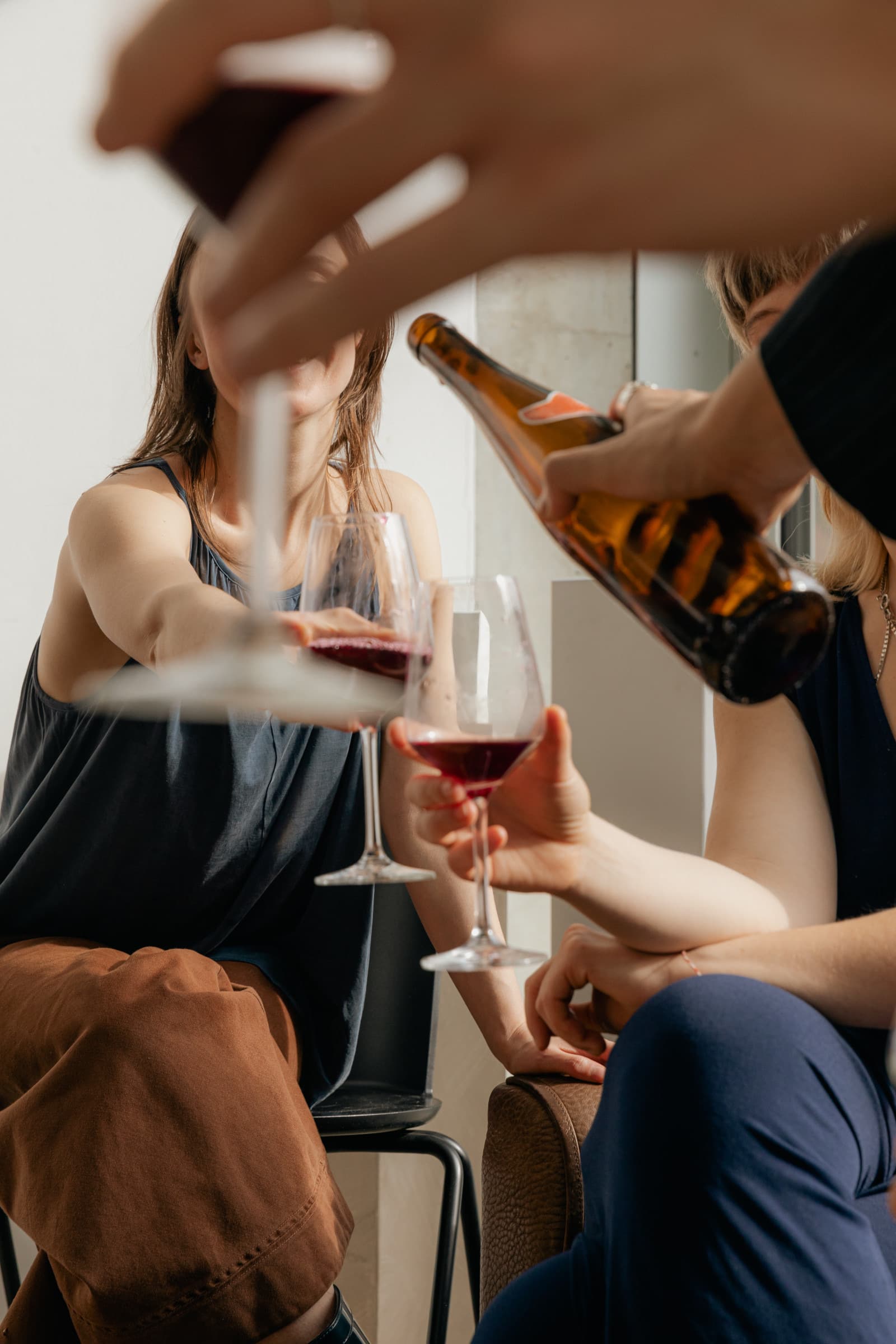Een gast krijgt rode wijn ingeschonken aan tafel