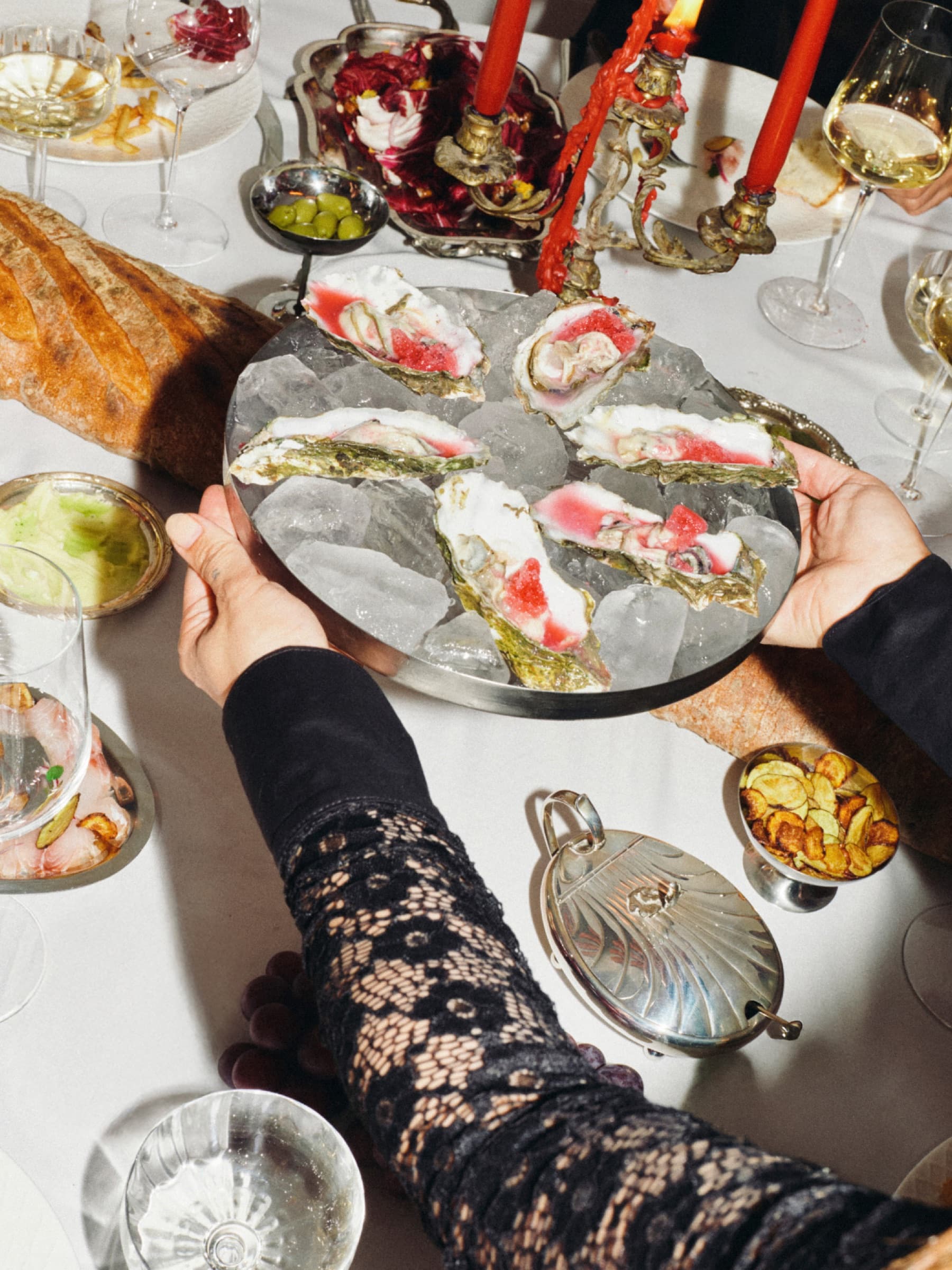 Een schaal oesters wordt op een feestelijk gedekte tafel gezet