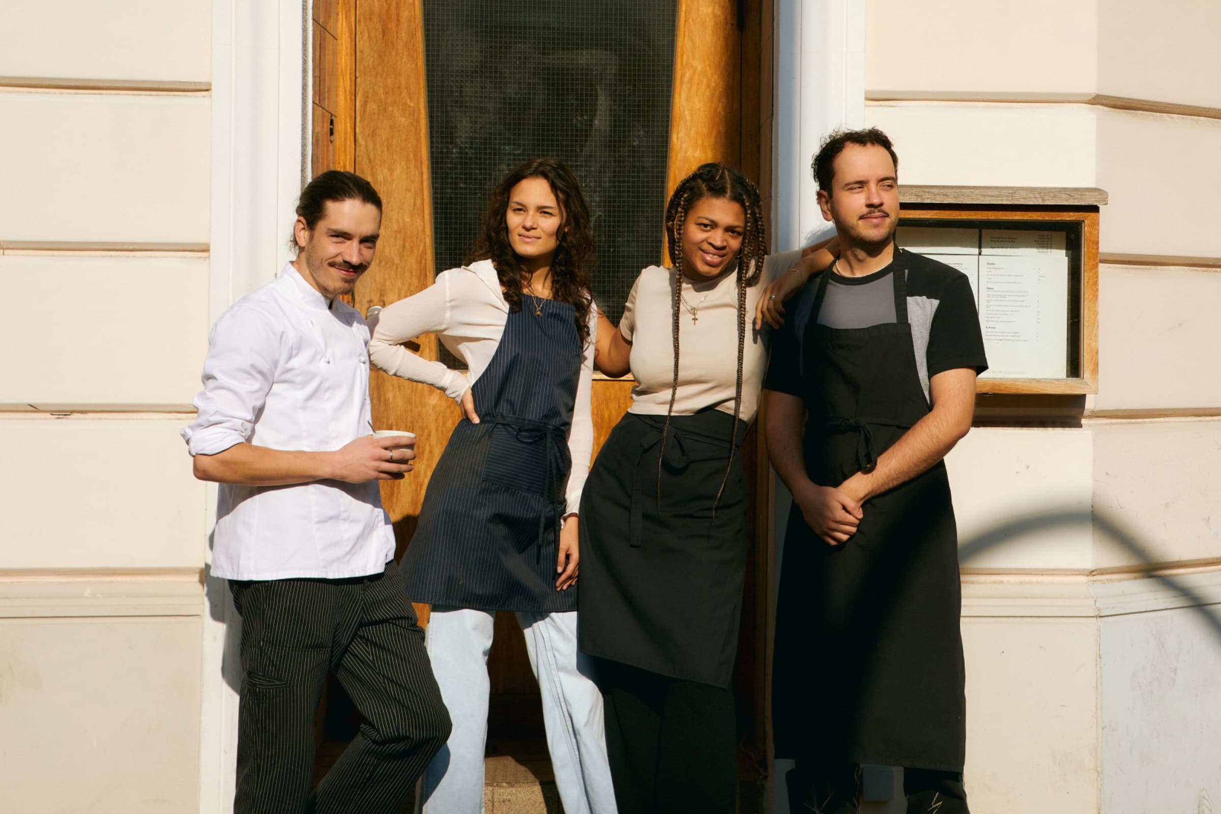 Het team van een restaurant staat samen bij de ingang